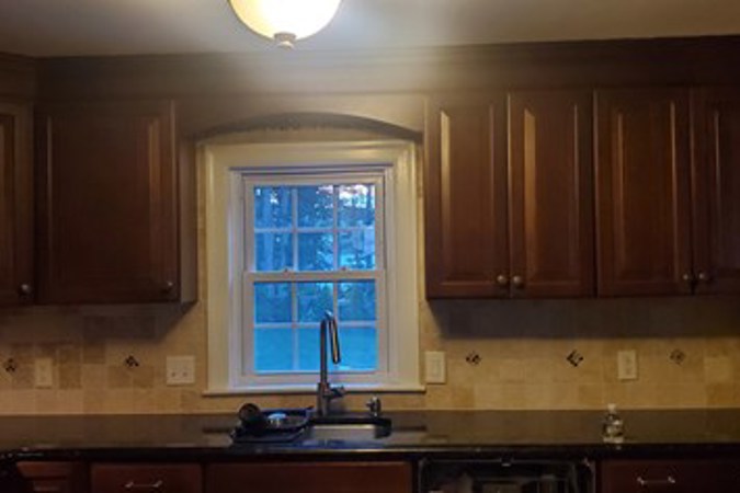 Before: Kitchen with dark cabinets and countertops